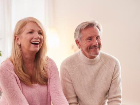 Lächelnde Frau und Mann sitzen bei einer Veranstaltung