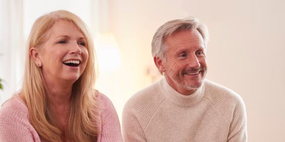 Lächelnde Frau und Mann sitzen bei einer Veranstaltung